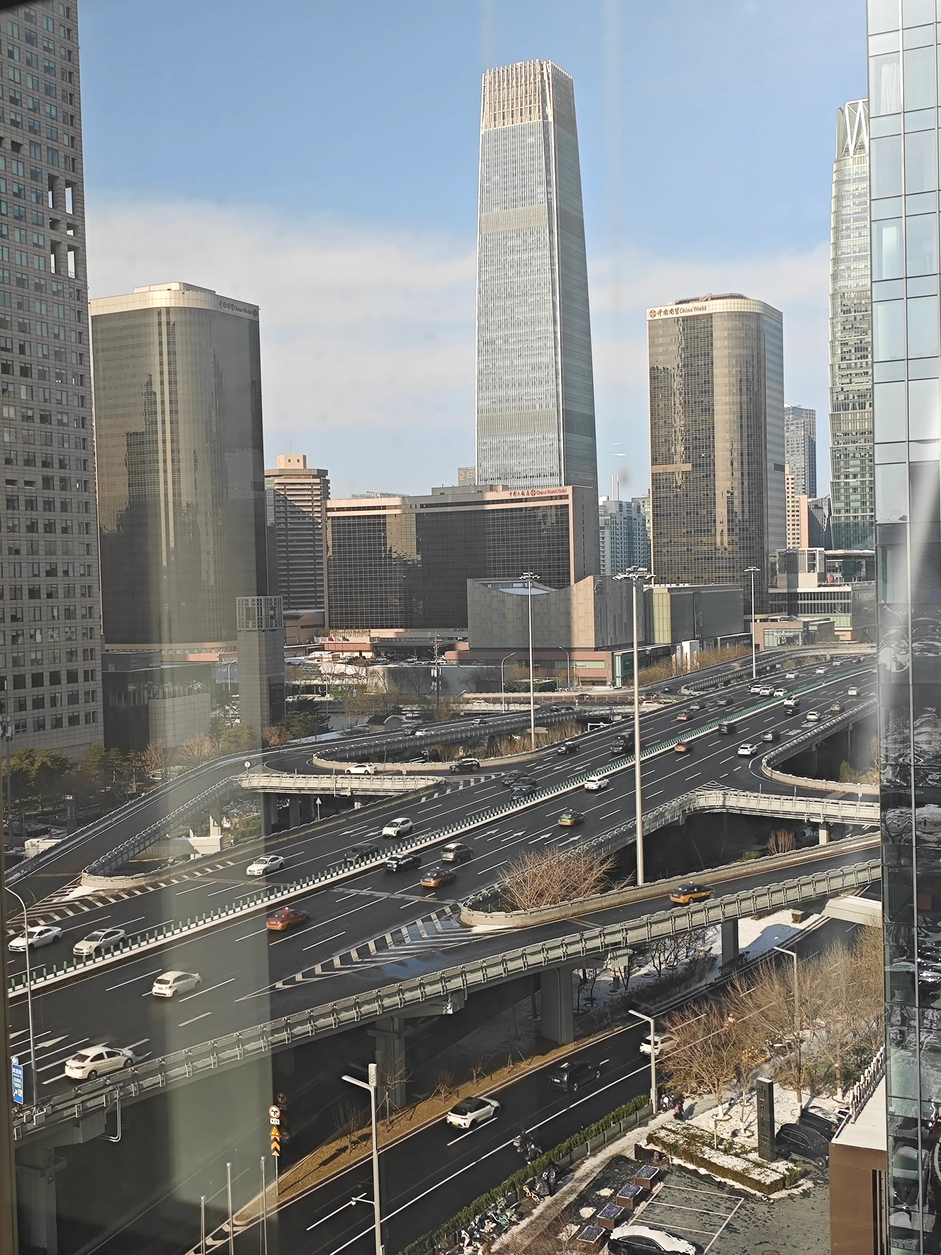 初雪后的北京：从公司窗边俯瞰国贸立交桥与车流